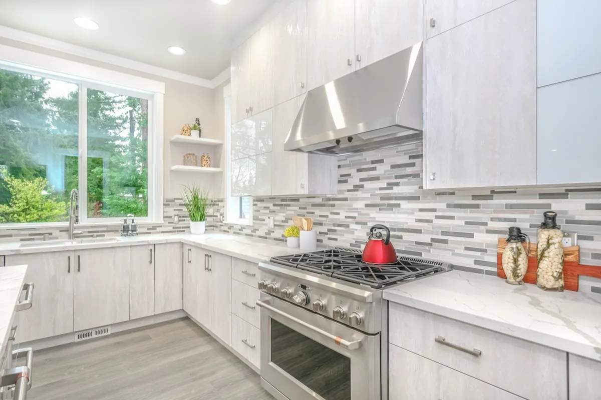 Kitchen with mosaic tile backsplash and white cabinets