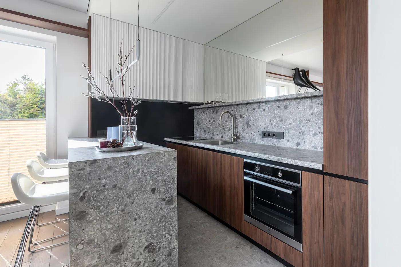 Kitchen with granite slab island and walnut cabinets