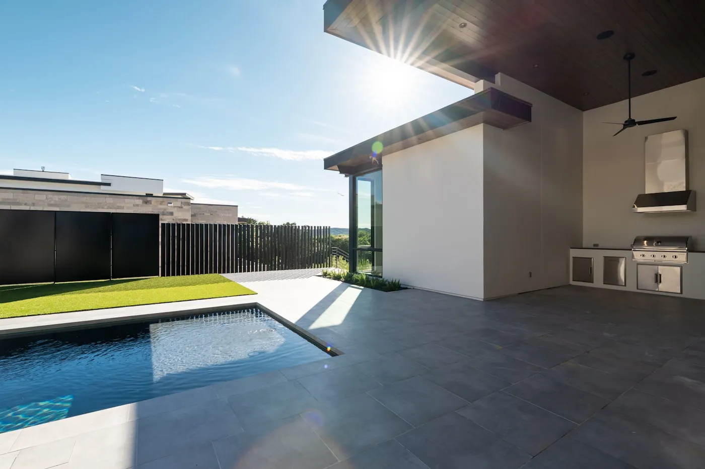 Poolside patio with tile deck and outdoor grill