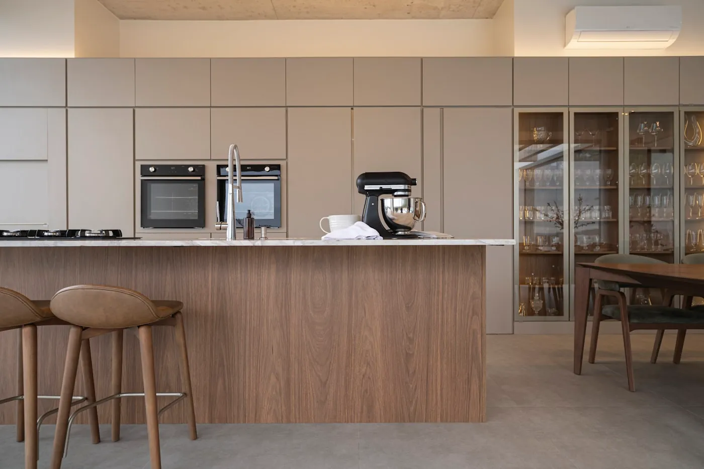 Minimal kitchen with warm wood island and stone top